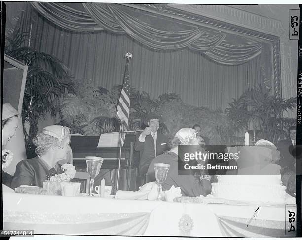 The camera angle makes it seem as if Mrs. Dwight Eisenhower is about to get a mouthful of cake as she lets go with a hearty chuckle during a birthday...