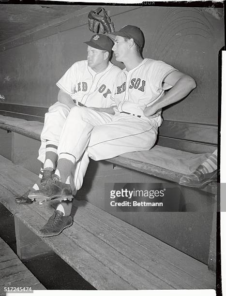 Ted Williams and manager Joe Cronin talk things over in the Red Sox dugout before game.
