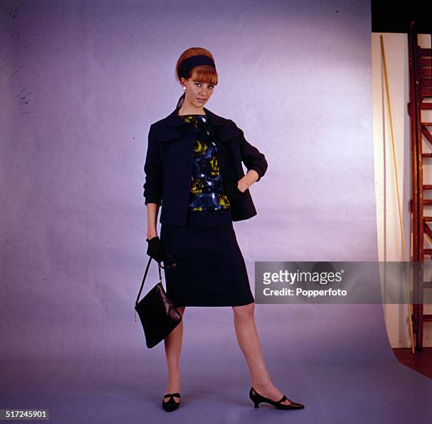 Sixties Fashion - English model and actress Vicki Hodge posed wearing a dark jacket and matching skirt circa 1964.