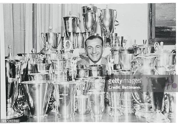 Speedster's Spoils. Munich: German motorcycle champion H.P. Mueller is nearly lost among this collection of 203 silver and gold cups he's won in...