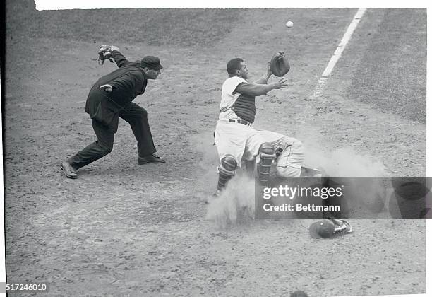 Pittsburgh Pirates right fielder, Lee Walls hits the dirt at home plate to score, as Brooklyn's Roy Campanella waits for Carl Furillo's throw from...
