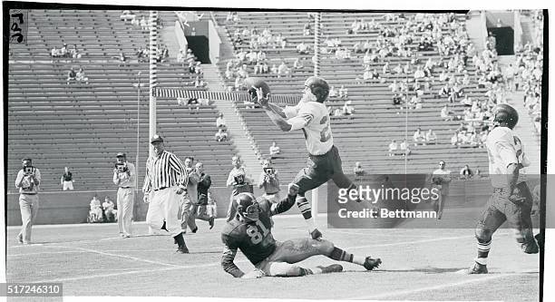 Improvised Step. Los Angeles, California: Washington State quarterback Bob Iverson uses the leg of Southern California's end Leon Clark to aid him in...