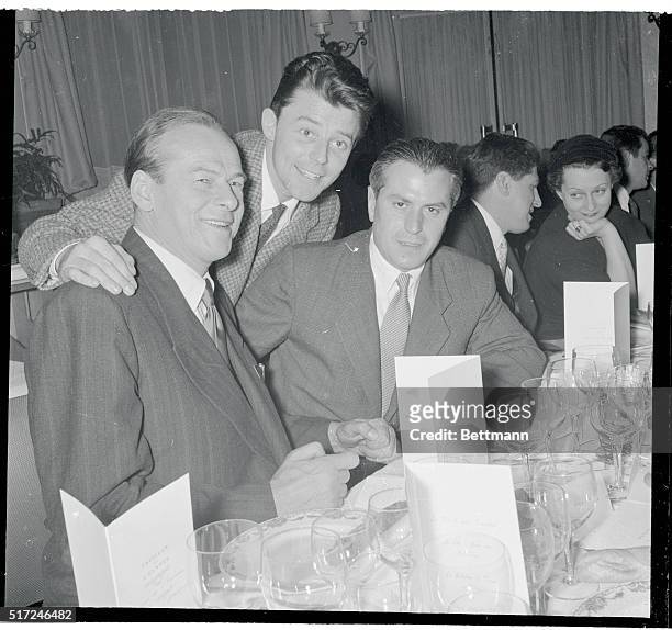 French movie star Gerard Philipe extends a friendly greeting to Soviet movie luminaries Tcherkassov and Birioukov, during a special luncheon in honor...