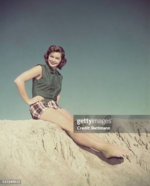 Sun Worshipper: MGM star Esther William wears these gay plaid shorts topped by a vest of forest green linen for a day at the beach. Miss William is...