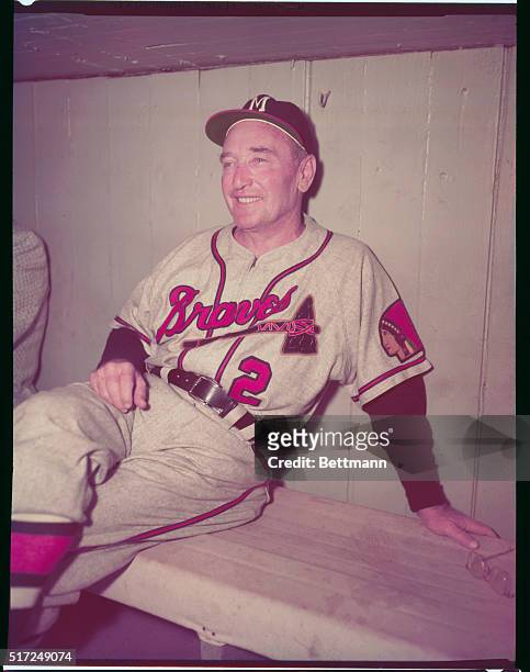 Former manager of the Pittsburgh Pirates, Fred Haney sits on the bench and smiles as the new manager of the Milwaukee Braves.
