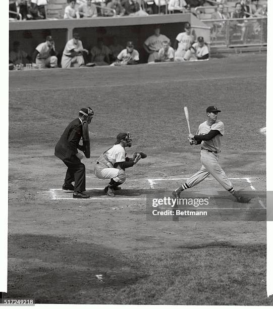 Displaying his flawless batting form even when striking out, Red Sox slugger Ted Williams swings and misses for strike tree in the 1st inning of the...