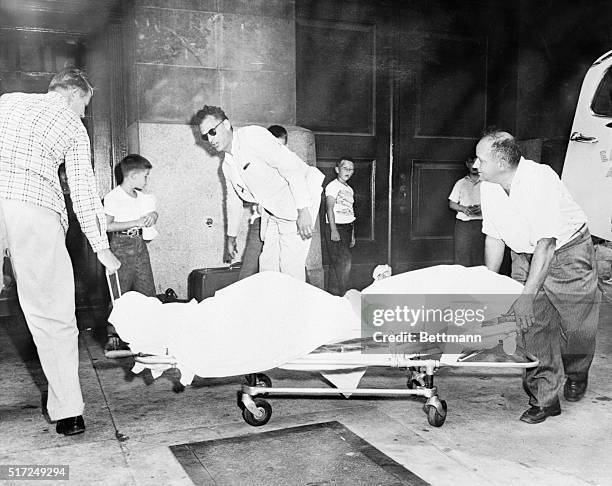 Actress Marilyn Monroe, covered by a sheet, is wheeled on a stretcher into Doctor's Hospital here August 1st after being rushed 100 miles from her...