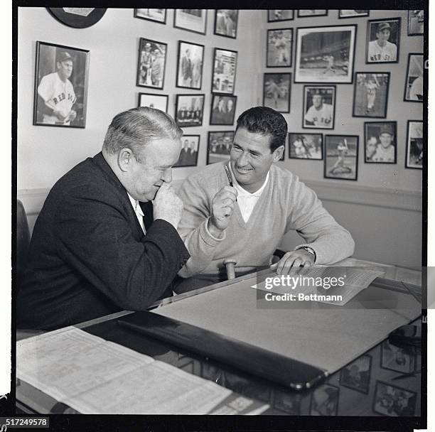 Ted Williams, Boston Red Sox slugger, , is all smiles here after signing his 1958 contract to play for a reported $25,000. Witnessing the signing is...