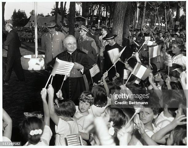 Continuing his current tour of Rome, New York's Francis Cardinal Spellman is greeted by flag-waving youngsters during his visit to the "November 4th...