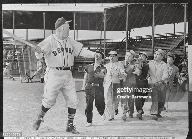 "Go away, you bother me!" This looks like infield practice in the Pee Wee League. It's not, nor is it the distressed gentlemen with the bat Gulliver...