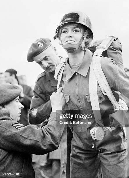 On location for her latest film, Babette Goes to War, sexy French actress Brigitte Bardot is helped into a parachute at a royal air force base for a...