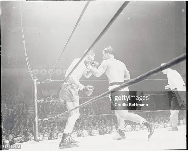 New York: Rocky Marciano lands a blow as ex-heavyweight champ Joe Louis backs up against the ropes during the first round of their scheduled...