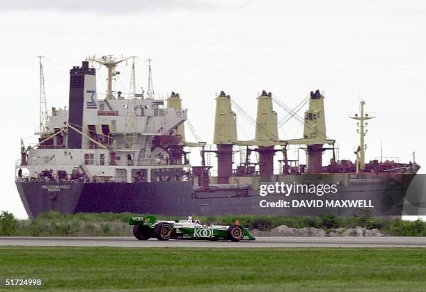 Scottish Driver Dario Franchitti drives past a ship floating on Lake Erie during the final lap of the Marconi Grand Prix of Cleveland 01 July 2001 at...