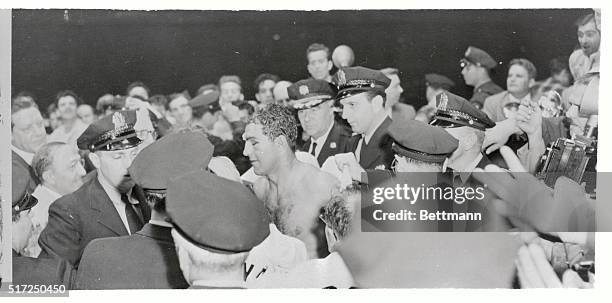 Police move in to escort the new heavyweight champion Rocky Marciano from the ring here, after the Brockton, Massachusetts blockbuster knocked out...