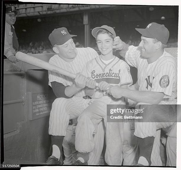 New York, Yankee outfielder Gene Woodling takes time out from a serious discussion about batting, to pinch the cheek of Tiny Dimeglio, star of the...