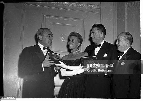 New York, New York- Singer Mary Martin, just returned to the United States from England, makes a presentation of small gold plaques to composer,...