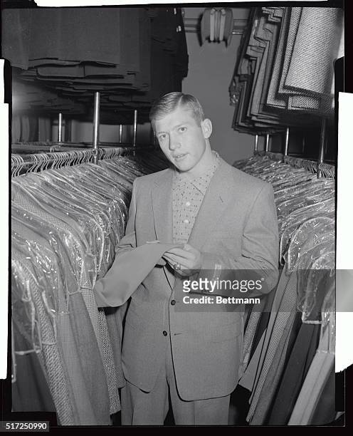 Mickey Mantle, New York Yankees' young out fielding star, inspects some civilian suits as he shops in New York preparatory to reporting to the spring...