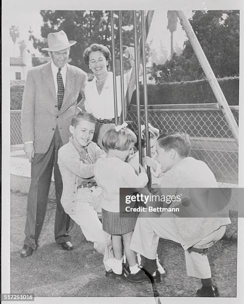 Actor James Stewart enjoys a relaxing back yard session with his charming wife Gloria and the little Stewarts. The younger members of the Stewart...