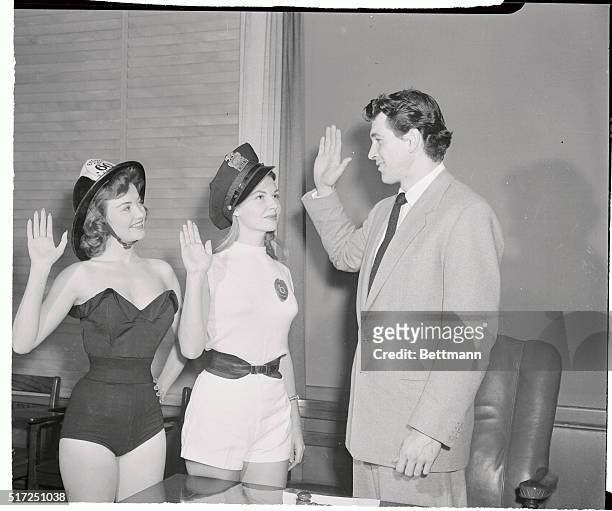 Screen actor Rock Hudson, the newly elected Mayor of Universal City, swears in his fire chief and police chief, actresses Jackie Loughery definitely...