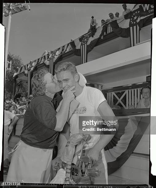 Patty Berg, of St. Andrew's Country Club near Chicago, gives a big kiss to her caddy Paul Tyrcha, after the freckled pro copped first place in the...