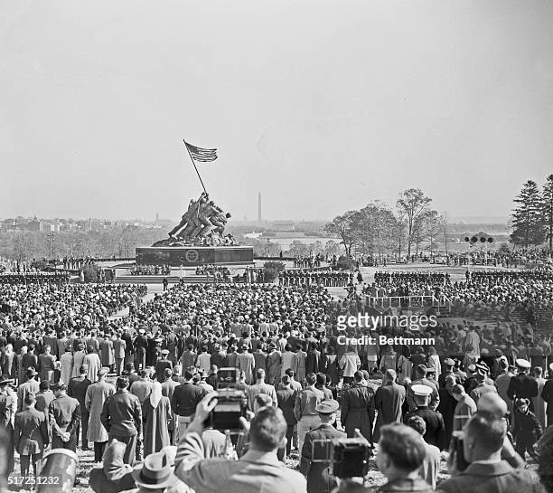 Spectators look on during the formal dedication of the U.S. Marine Corps War Memorial near Arlington National Cemetery. Depicting the flag raising on...