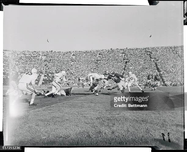 Michigan's Terry Barr stops Minnesota's quarterback Don Swanson as the latter returns a punt to his own 27 yard line in the third quarter of a clash...