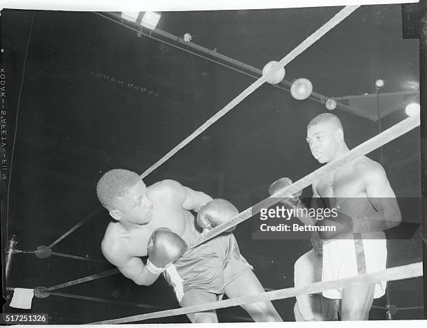 Teddy "Red Top" Davis batters Percy Bassett through the ropes during their 12 round featherweight go at New York's Madison Square Garden. Davis was...