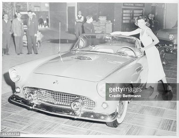 The new Ford "Thunderbird" sports car has its graceful lines matched by a lovely girl as it goes on display at the London Motor show in Earls Court....
