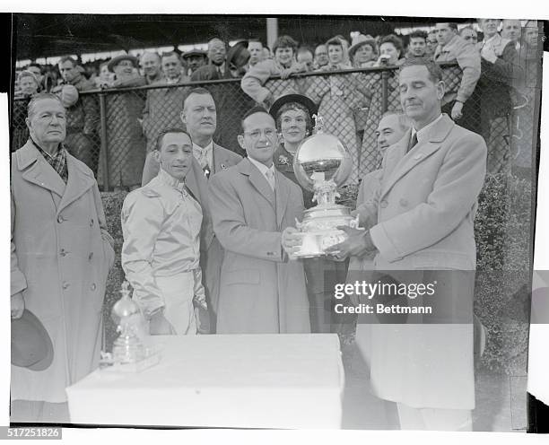 Cornelius Vanderbilt Whitney receives the Washington, DC, International trophy from track president John D. Shapiro following his horse's victory at...