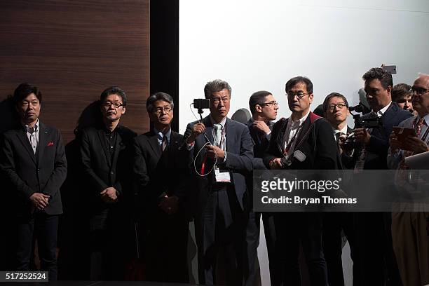 Mazda executives and members of the press watch President of Mazda North American Operations Masahiro Moro introduce the world premiere of the Mazda...