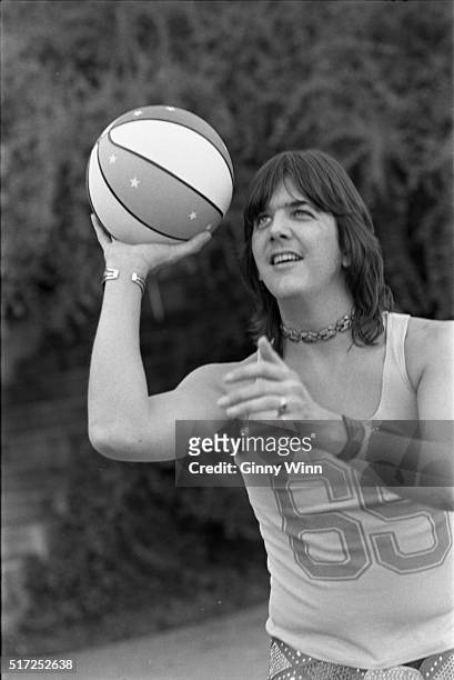 Singer/Musician Gram Parsons plays basketball in a backyard in 1973 in Los Angeles, California. .