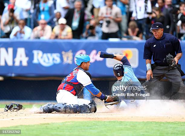 Kevin Kiermaier of the Tampa Bay Rays slides safely into home as Frank Morejon of the Cuban National team applies the tag during the game at Estadio...