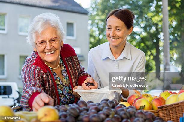 betreutes wohnen-senior frau und fürsorgliche shopping - assisted living stock-fotos und bilder