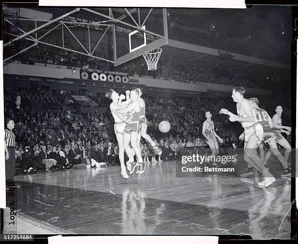 Boston's Arnie Risen, , seems to want to cut in on the aero doings of teammate Ernie Barrett and Neil Johnston, , of Philadelphia during jump for...