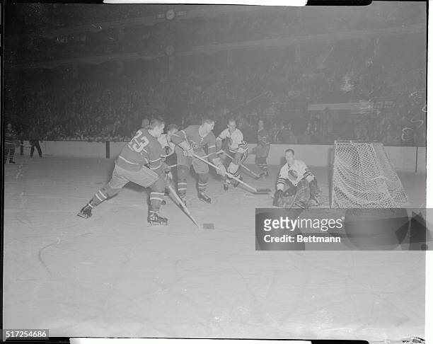 Black Hawk's goalie Al Rollins saves shot of Jean Beliveau, , of the Montreal Canadiens during first period of play in the Chicago Stadium. Man in...
