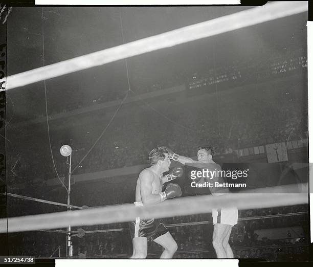 Carmen Basilio connects with a left to Tony DeMarco's head in the fifth round in this ringside photograph.