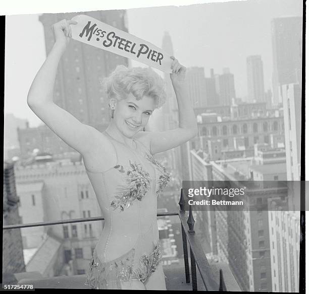 With the New York city skyline offering an impressive backdrop, pretty Christina Logan displays her title above her head, as she poses atop the...