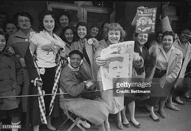 Teenager proudly displays a drawing of Elvis Presley as she waits with other fans outside the Paramount Theater here on November 15th, to see the...