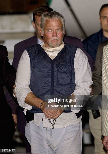 Fugitive Ira Einhorn is escorted in handcuffs out of a plane early 20 July 2001, in Philadelphia, PA, after US Marshalls flew him from France....