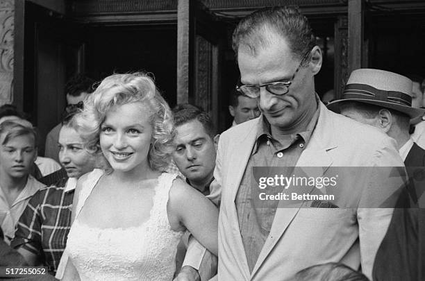 Looking as lovely as ever, Marilyn Monroe and her husband, Arthur Miller, talk with newsmen as they leave Doctor's Hospital August 10th. Marilyn...