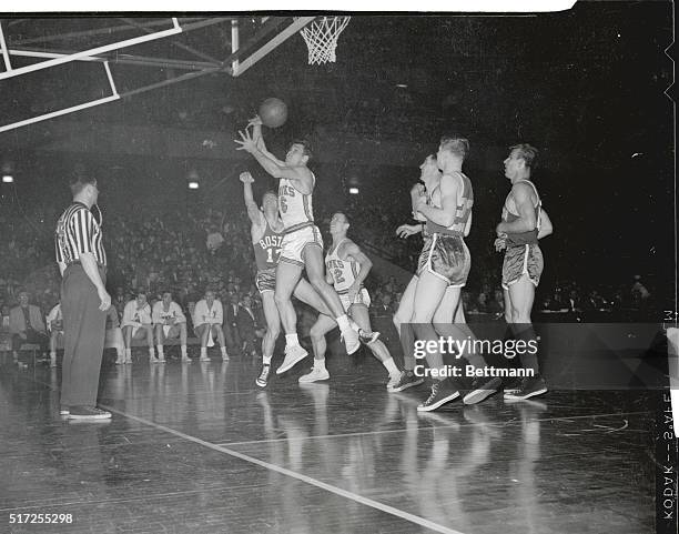 Cliff Hagen of the Hawks battles Andy Phillip of the Celtics for this rebound, as Med Park of the Hawks looks on. Action came in the frist quarter of...