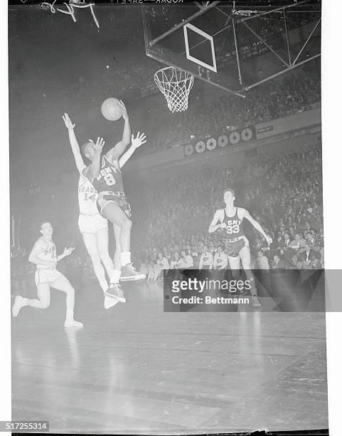 New York, New York: With Charles Grover, , of Bradley, trying to recapture the ball, Ed Warner, , of CCNY, is shown taking the rebound after a...