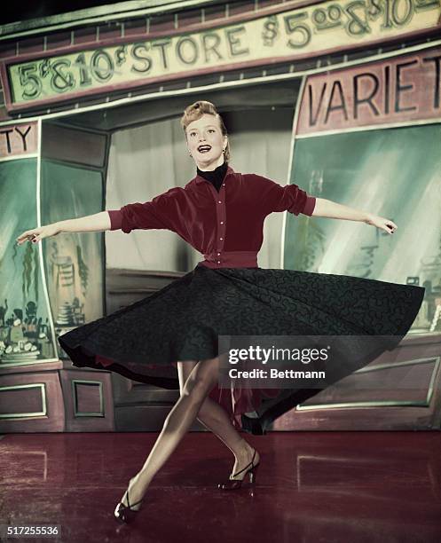 Actress Pat Wymore, dancing with swirled dress and also waist up, posed, smiling.