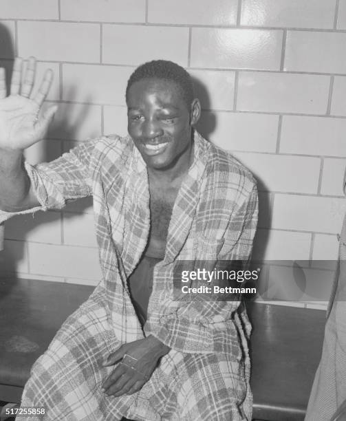 New York: Jumpin' For Joy: Ezzard Charles is shown in his dressing room joyously waving after he won the unanimous decision of the judges in...