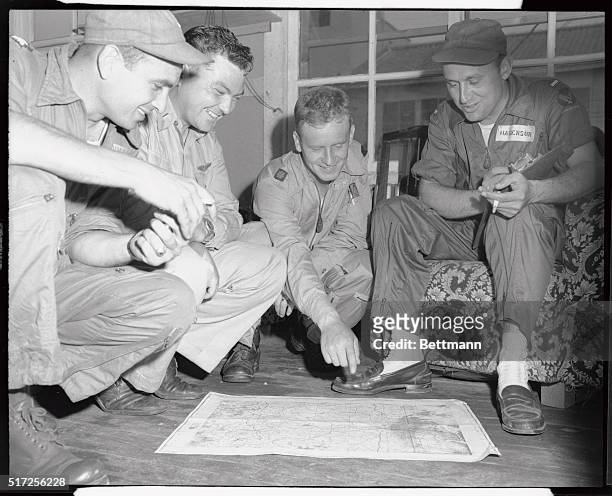 These members of the 35th Fighter Group are looking mighty pleased with themselves as they point out on a map of Korea the targets they've been...
