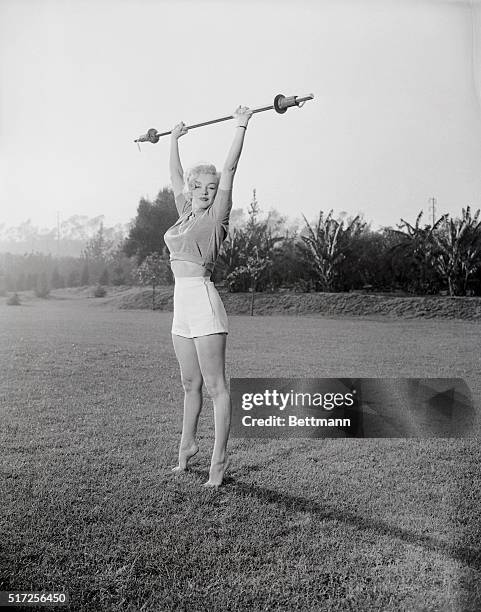 Reaching for the sky on tiptoe, the barefoot advocate shows how to keep those curves. Walking is the only exercise Marilyn takes to keep her figure...