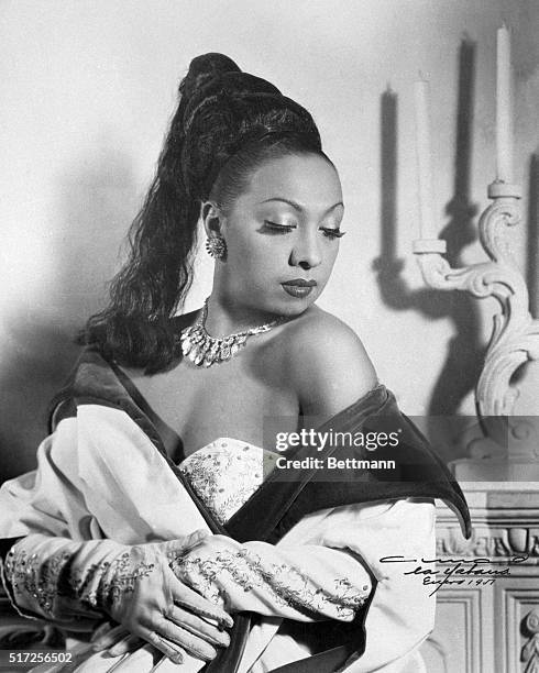 Exotic Josephine Baker, shown wearing one of her gorgeous gowns and opera gloves, part of her $150,000 collection of gowns and furs, returned to...