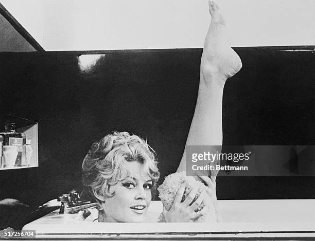 Brigitte Bardot holding up leg in bathtub in the 1957 film Une Parisienne.