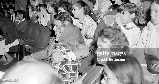 Cuddled tenderly by her husband, actor Jacques Charrier, actress Brigitte Bardot attends a special showing of the film "Babette goes to war" at the...