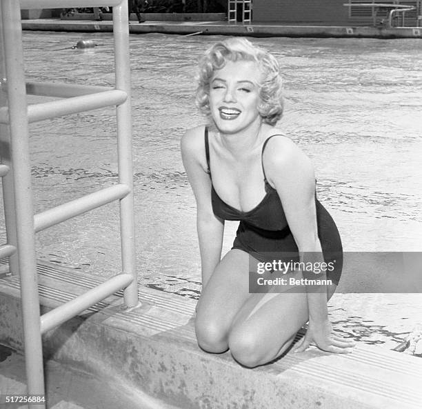 Marilyn Monroe in swimsuit by pool side.